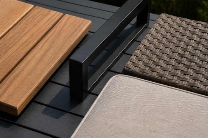 Close-up of teak wood, metal, woven wicker and outdoor cushion fabric